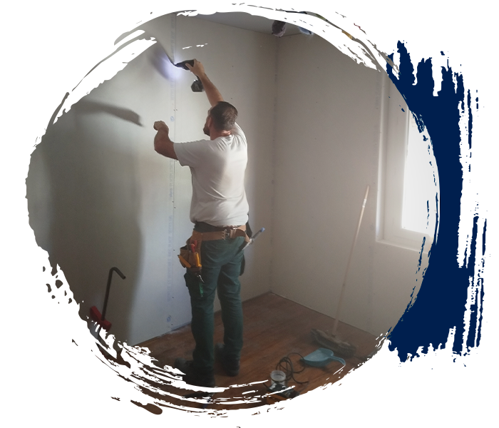 Artisan plaquiste réalisant la finition des plaques de plâtre au plafond lors d’un chantier de rénovation intérieure