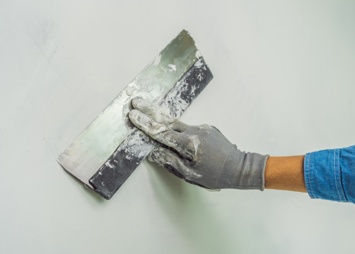 Application d’enduit de lissage à la lisseuse sur un mur pour une finition prête à peindre