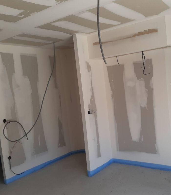 Pièce en rénovation avec cloisons et plafond en placo, bandes à joints en cours pour une finition nette avant peinture